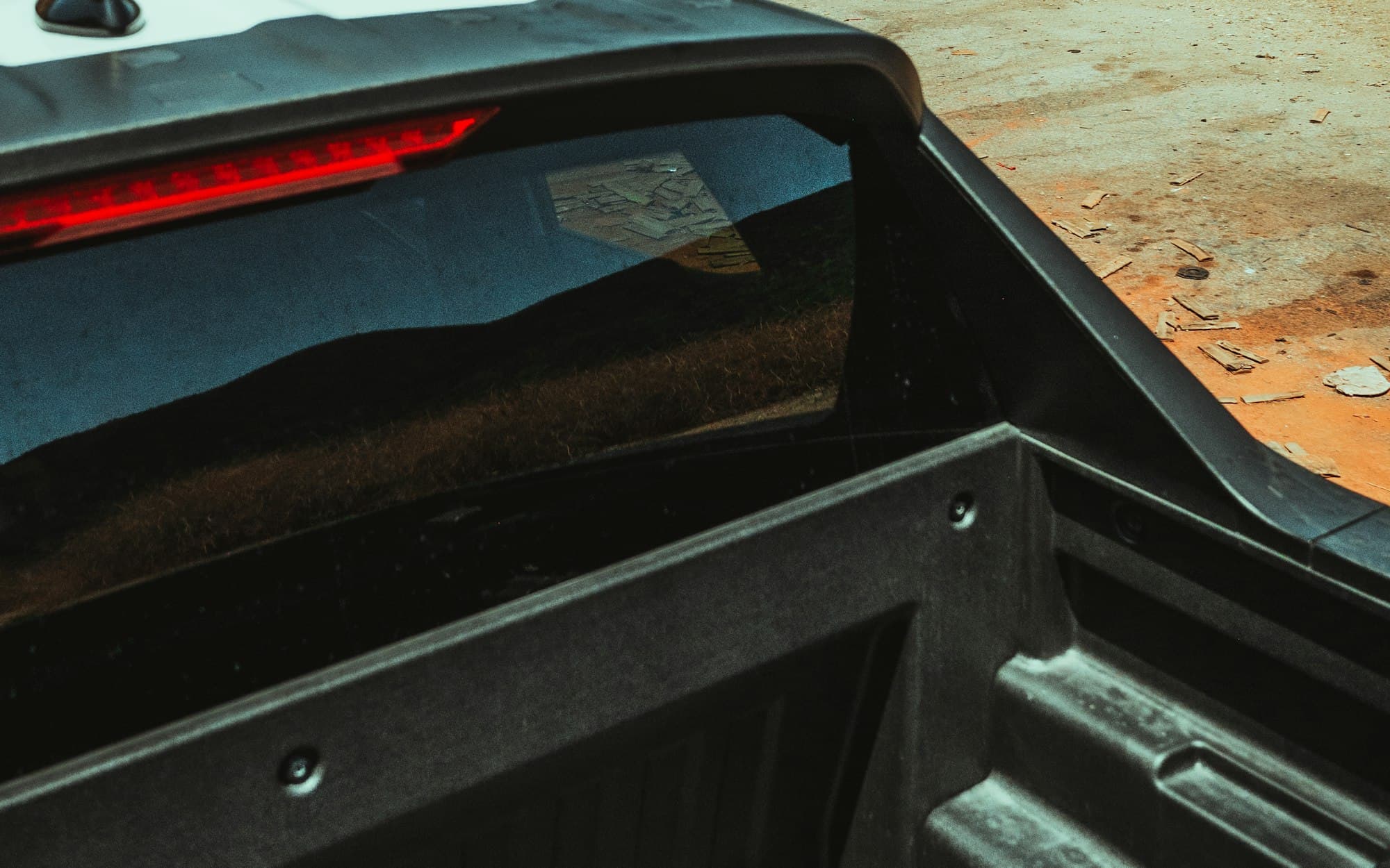 Looking into an open pickup bed with a bed liner, from just behind the cab